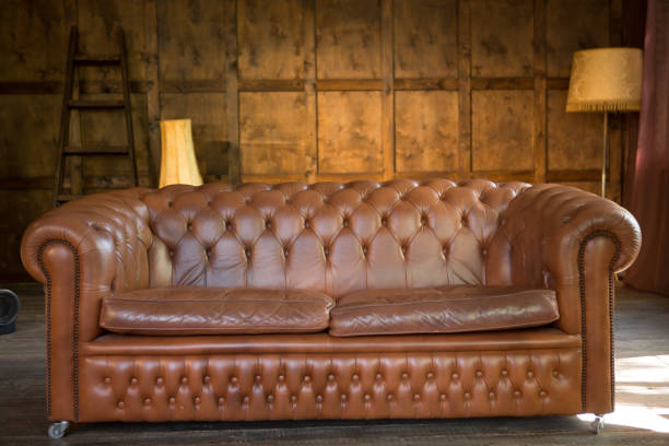 istock Solid leather sofa in a wooden interior. Brown color couch in home or office loft style interior 1255440415