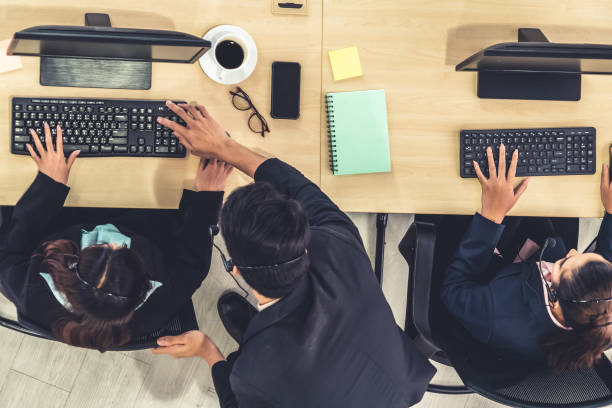 istock Business people wearing headset from top view in office working with computer 1255441341