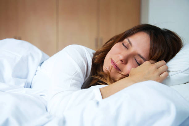 istock Young latin american woman sleeping peacefully in bed 1255442441