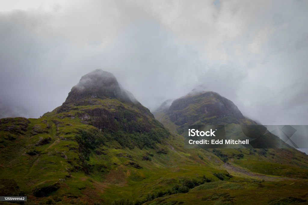 Mountains covered in cloud, Scotland, UK Two mountain peaks, shrouded in cloud, Glencoe, Scotland, UK Beauty Stock Photo