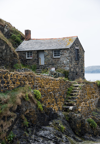 MULLION, CORNWALL, UK - SEPTEMBER 3, 2018.  The Net Loft at Mullion Cove in Cornwall is an example of an old fashioned stone, fisherman's cottage and a popular Cornish tourist attraction.