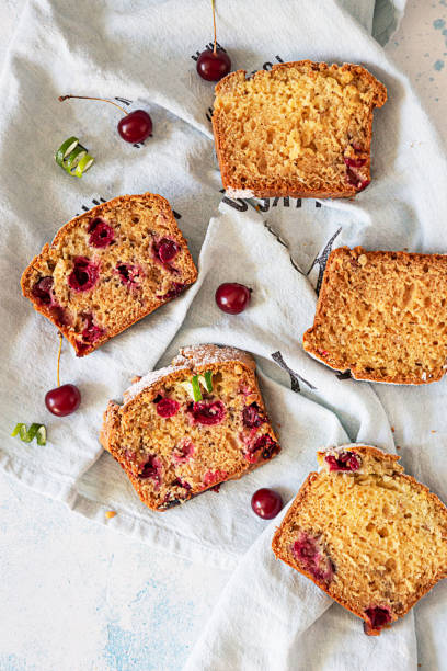 piezas de pastel de nuez con cereza sobre servilleta de lino, fondo de hormigón claro. panadería fresca casera para el desierto. vista superior. - pound cake fruitcake cake loaf of bread fotografías e imágenes de stock