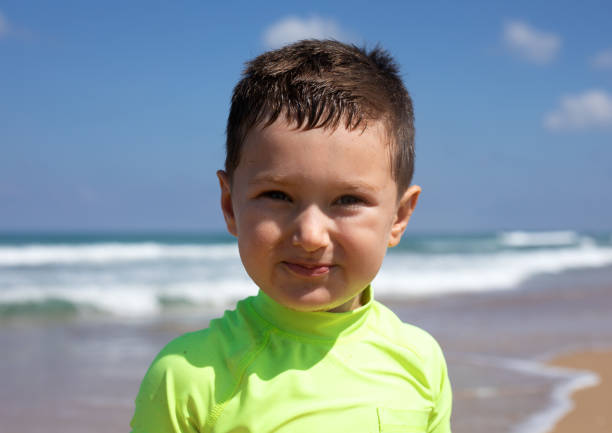 Alex Kolesnikov on the Mediterranean coast in Haifa. The child is smiling and looking at the camera.
