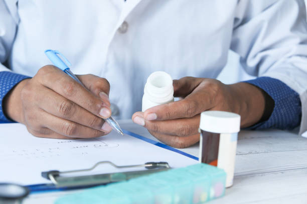 istock doctor hand writing prescription on desk, close up 1255448157