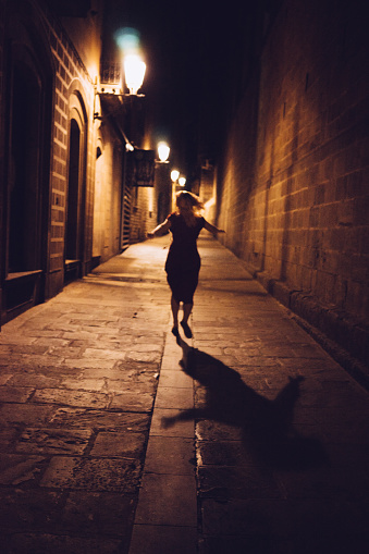 Runaway Girl running away in the Night Lights Street Barcelona. Gothic Quarter - Barcelona.