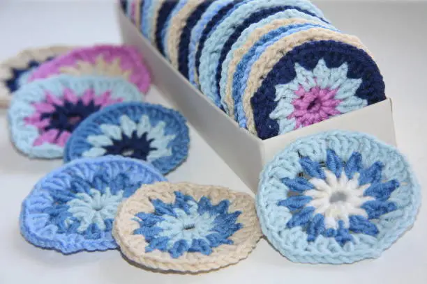 Photo of Knitted round pattern of cotton yarn in different colors.