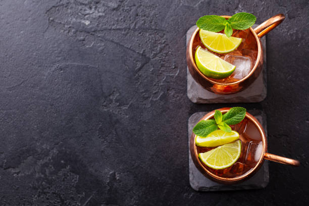 istock Moscow Mules cocktail with ginger beer, vodka, lime and mint. Grey background. Copy space. Top view. 1255451570