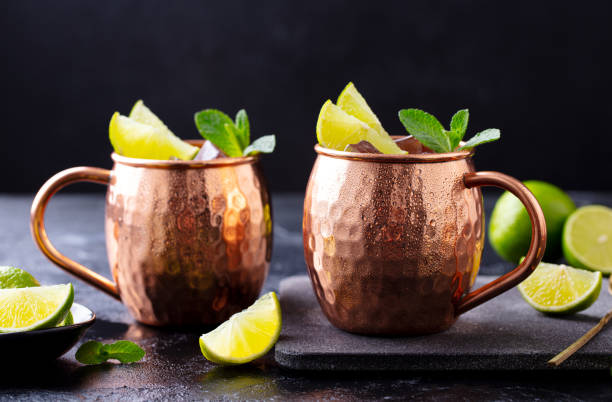 istock Moscow Mules cocktail with ginger beer, vodka, lime and mint. Grey background. Close up. 1255454712