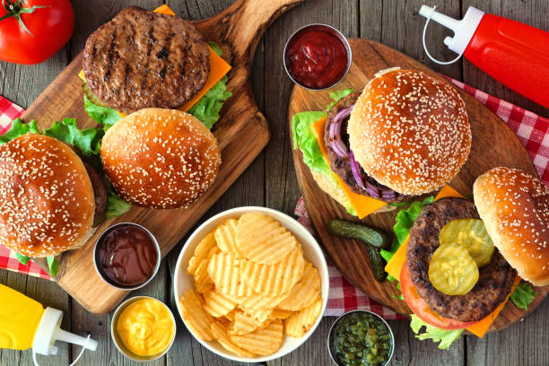 istock Summer BBQ hamburger table scene, above view over wood 1255455856
