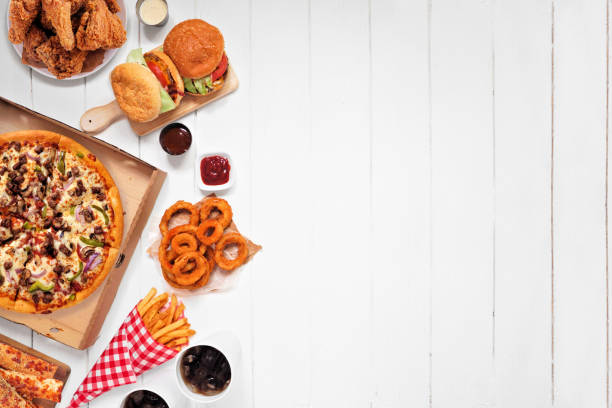 istock Assorted take out or delivery foods, above view side border on a white wood background 1255456562