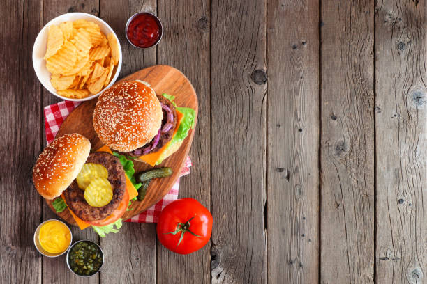 istock BBQ hamburgers on a serving board, above view on a dark wood background 1255456578