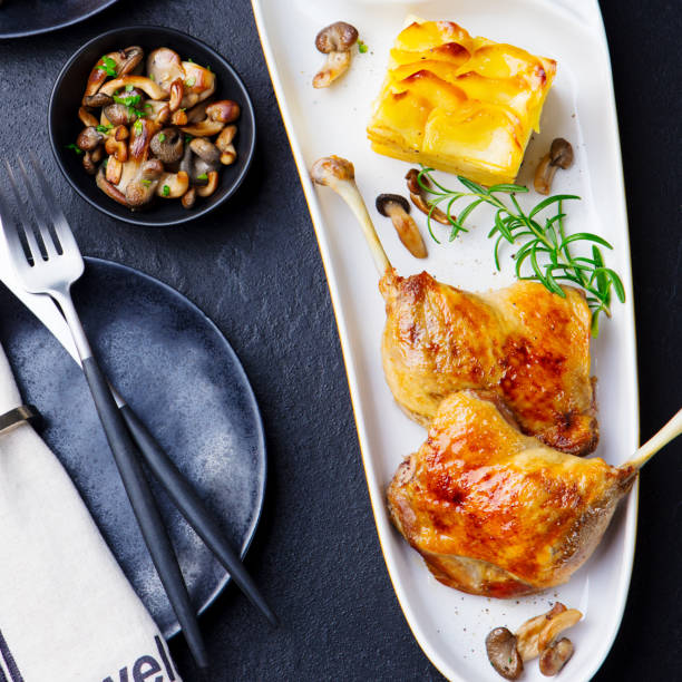 istock Duck legs confit with potato gratin and mushroom sauce. Top view. 1255458215