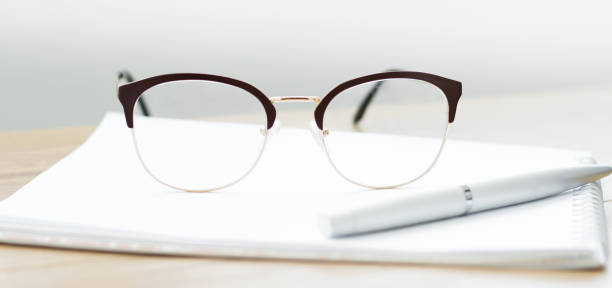 istock Close-up of glasses with a notebook on the table. Working space 1255458855