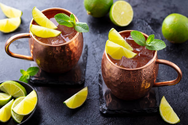 istock Moscow Mules cocktail with ginger beer, vodka, lime and mint. Grey background. Close up. 1255460914