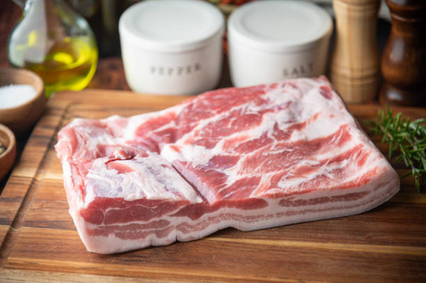 fresh pork belly block on wooden board