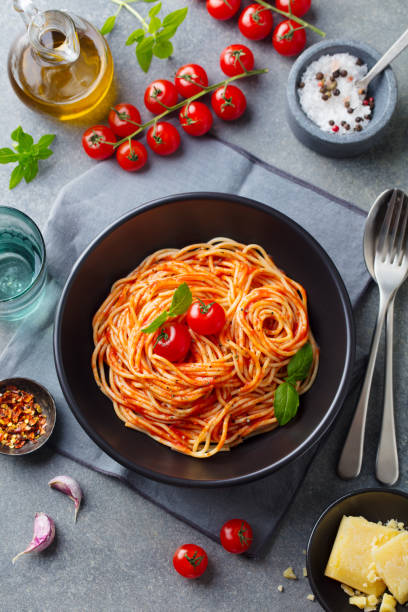 istock Pasta, spaghetti with tomato sauce in black bowl on grey background. Top view. 1255462979