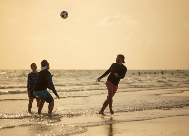 istock Hispanic people playing soccer on the beach in Florida 1255463041