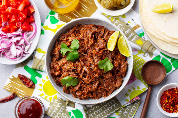 istock Mexican shredded beef with tortillas, vegetables and sauce. Grey background. Top view. 1255463242