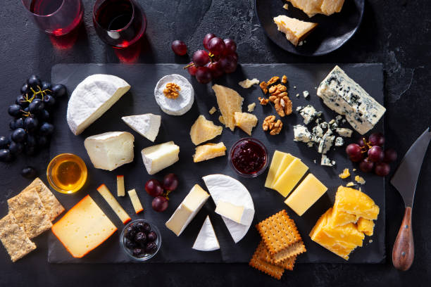 istock Cheese assortment on slate cutting board with red wine. Grey background. Top view. 1255463997
