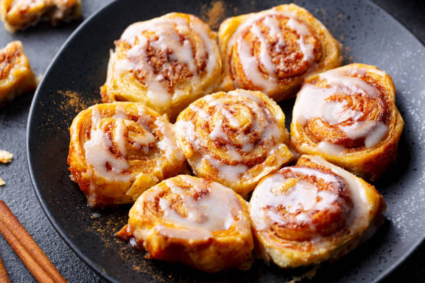 istock Cinnamon rolls, buns on black plate. Dark background. Close up. 1255465431