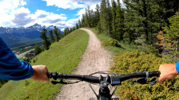 górski e-biker podąża szlakiem wzdłuż trawiastego zbocza - personal perspective mountain biking mountain bike cycling zdjęcia i obrazy z banku zdjęć