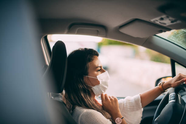 istock Woman Wearing a Sterile Mask While Driving Her Car 1255468664