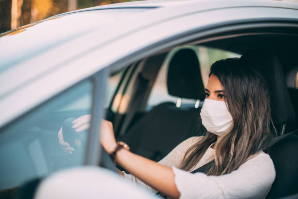 istock Woman Wearing a Sterile Mask While Driving Her Car 1255469891