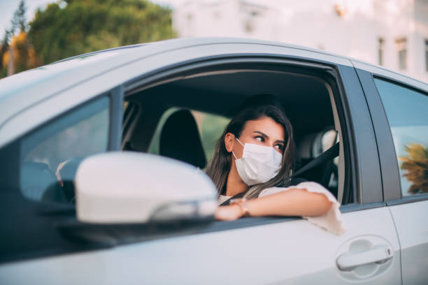 istock Woman Wearing a Sterile Mask While Driving Her Car 1255470185