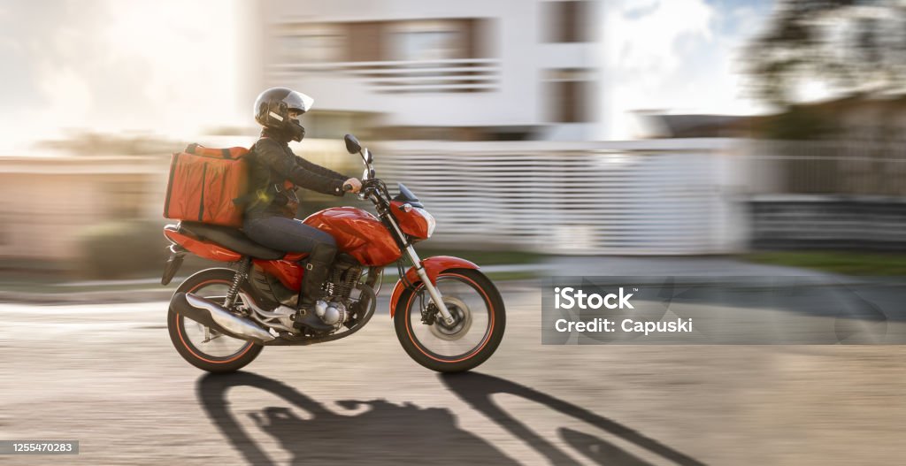 Biker in motion- Motogirl, Motoboy Biker in motion. Motorcycle Stock Photo