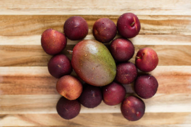 istock Fresh Deep Purple & Red Plums with a Green & Red Mango 1255473508