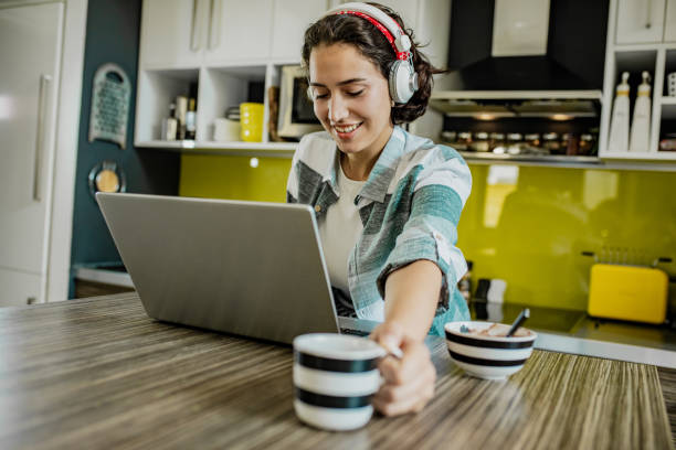 istock Young woman is working from home and drinking coffee in the morning 1255474832