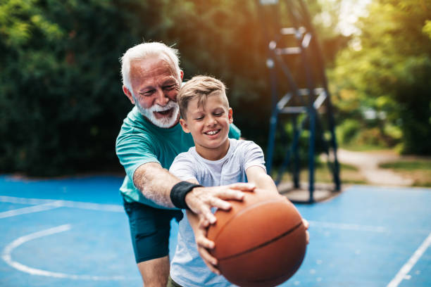 grand-père et petit-fils sur le terrain de basket-ball - grandfather grandson active seniors senior adult photos et images de collection