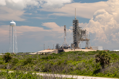 A launch pad and support structures are surrounded by thick vegetation at Florida's Kennedy Space Center.