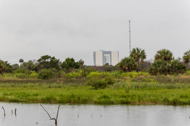Massive structures at the Kennedy Space Center stand in contrast to lush foliage along the Indian River near Titusville, Florida.