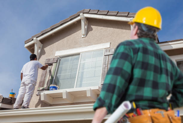 istock Contractor Overlooking Painter Painting House 1255481258