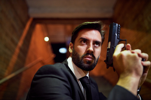Spy thriller book cover design with man holding pistol gun.