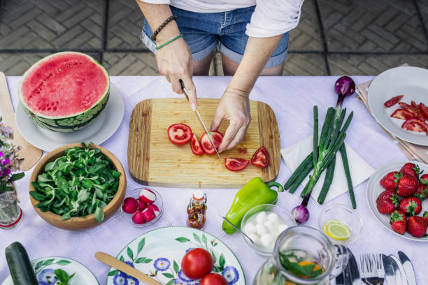 istock Woman making fresh salad on table 1255483293