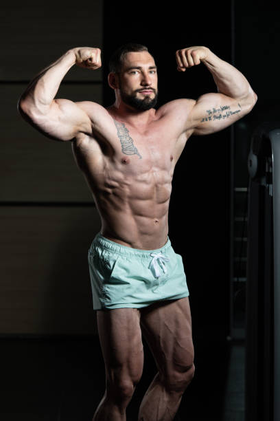 istock Muscular Men Is Hitting Rear Double Bicep Pose 1255490737