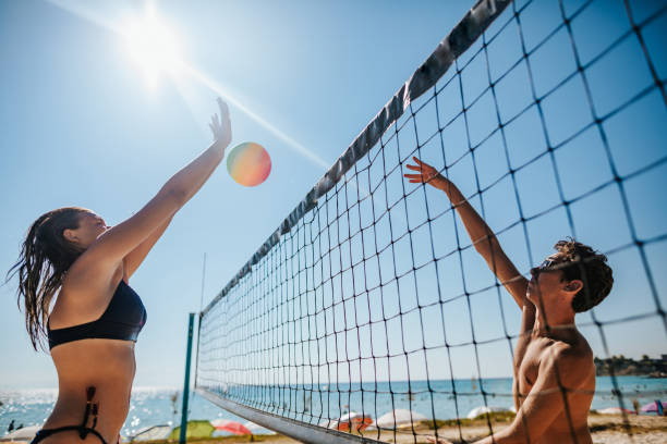 istock Young couple playing volleyball on the beach 1255493275