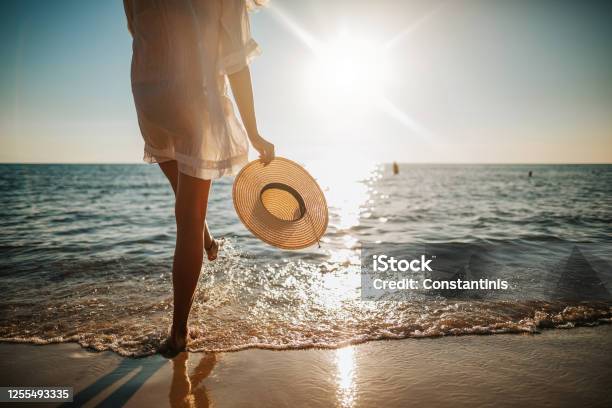 Womans Legs Splashing Water On The Beach Stock Photo - Download Image Now - Beach, Summer, Vacations