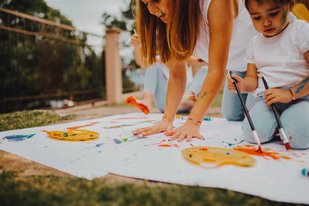 istock Mom with a child paint outside 1255497068