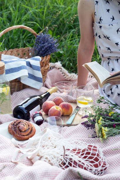 istock Summer - lemonade with lemon and mint with wine, peaches, cinnamon rolls, candles and a bouquet and a basket