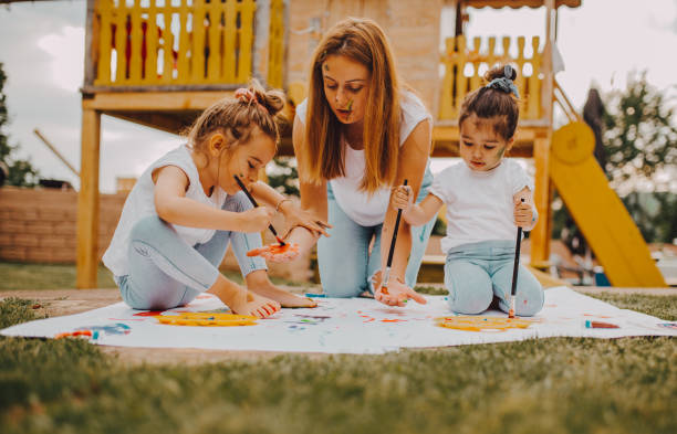 istock Mom with a child paint outside 1255498674
