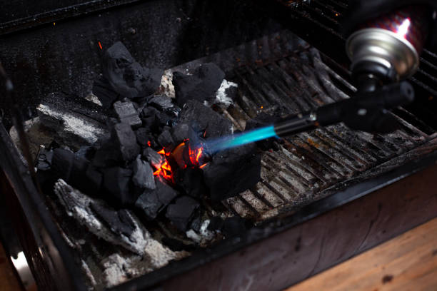 istock Torch with fire burning charcoal from a grill - lighting charcoal for the grill 1255502816