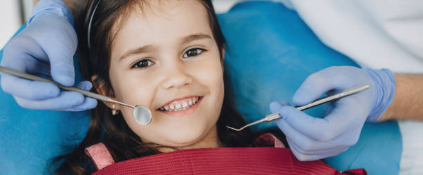 close up portrait of a caucasian girl having an examination at the pediatric dentist while smiling at camera - human teeth child smiling family imagens e fotografias de stock