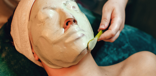 Alginate mask applied on the face of caucasian woman at the spa salon while lying