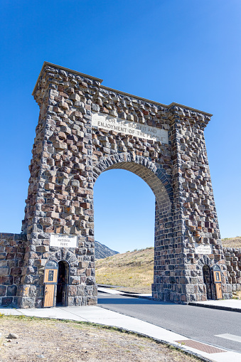 Historic Roosevelt Arch at the north entrance of Yellowstone National Park in Gardiner, Montana. The rusticated triumphal arch was built in 1903.