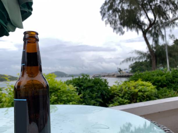 A Bottle of beer on the glasses table with sky mountain sea view landscape