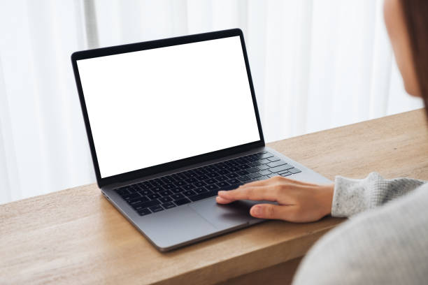 istock a woman using and touching on laptop computer touchpad with blank white desktop screen on wooden table 1255521202