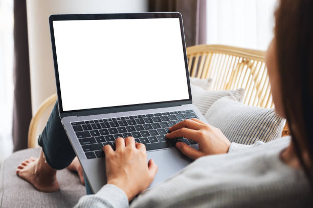 istock a woman working and typing on laptop computer with blank screen while sitting on a sofa at home 1255521257